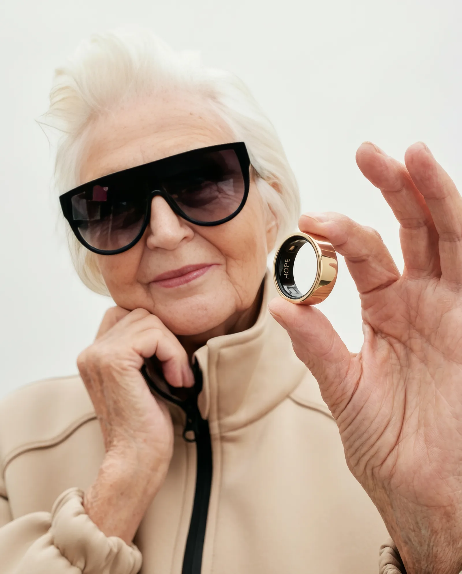 An older woman holding a gold HOPE ring